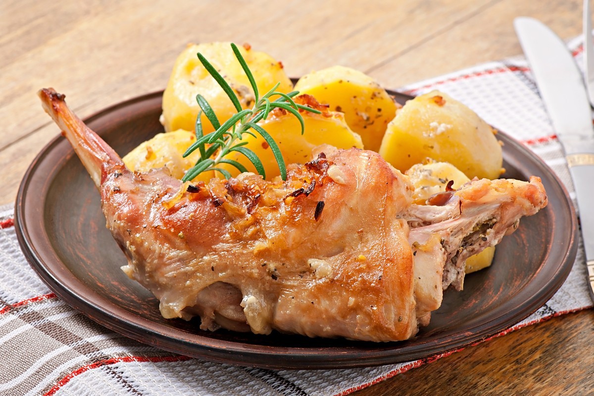 Gebackenes Kaninchen mit Kartoffeln und Zwiebeln im Ofen