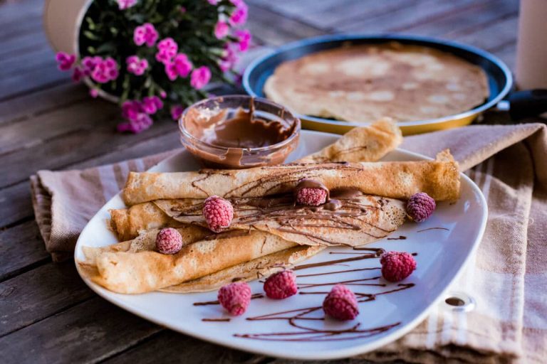 Leckere Crepes mit Schokosoße und Himbeeren